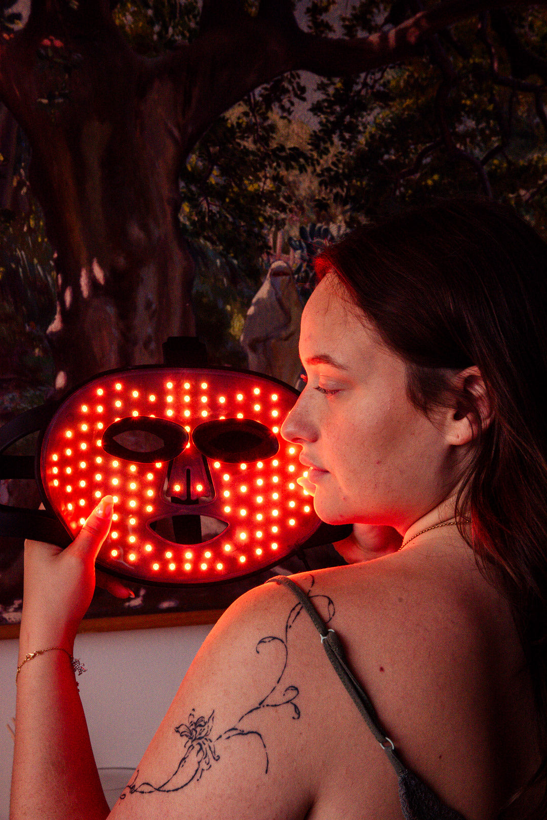 Femme utilisant le masque LED rouge Kalis-K en pleine lumière – soin lumineux premium pour la peau