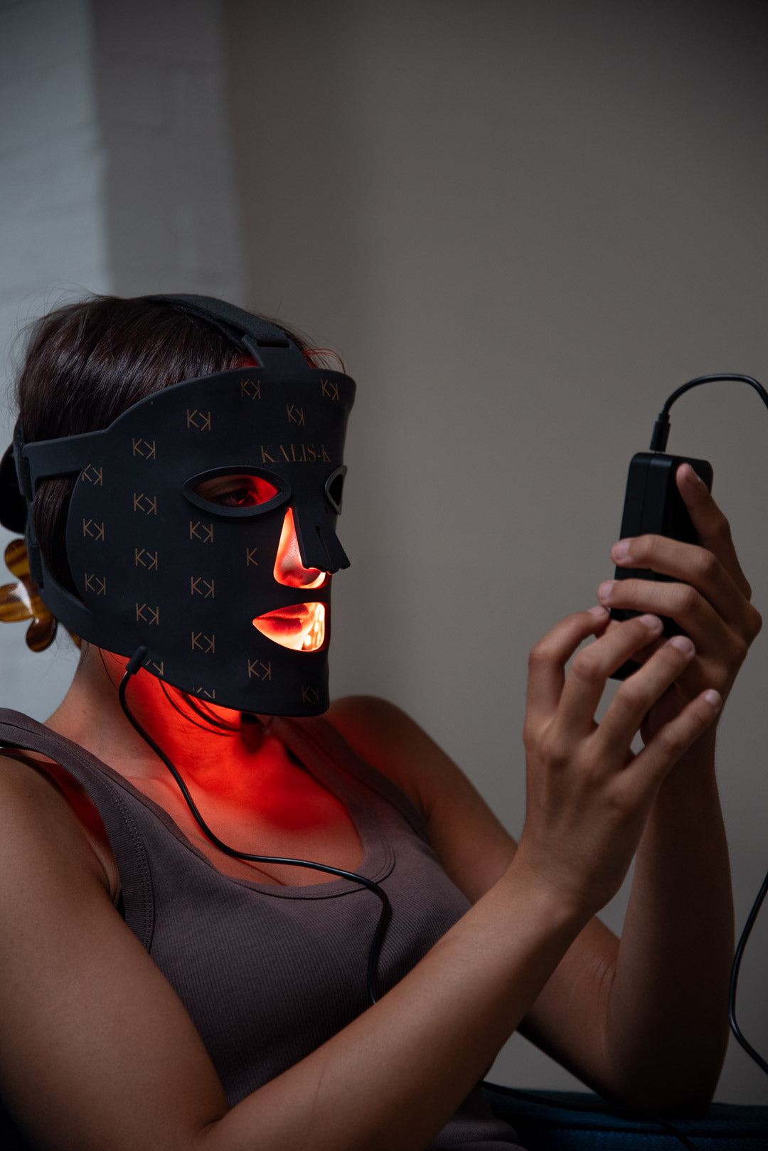 Femme utilisant le masque LED Kalis-K avec lumière rouge, séance quotidienne de luminothérapie à domicile.